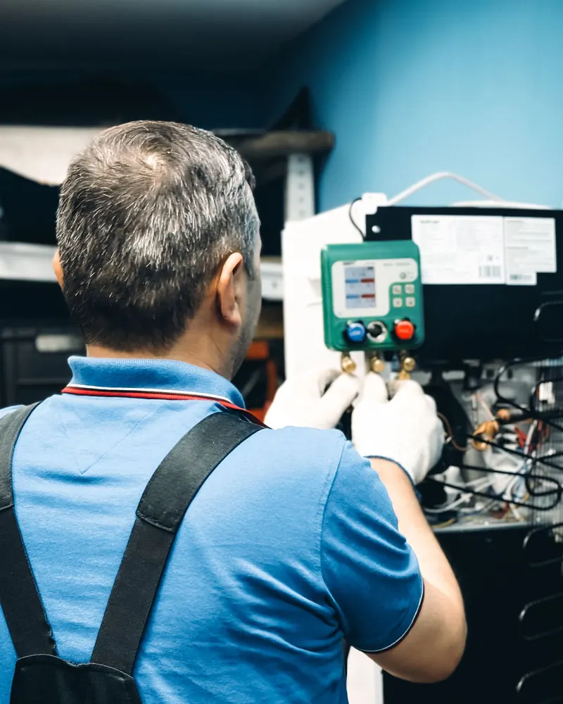 Technicien réglant un équipement de climatisation dans un local technique